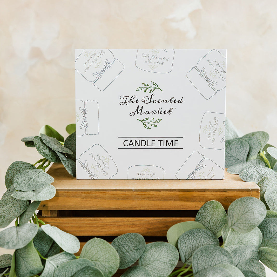 Product packaging for 'The Scented Market' candle time with eucalyptus leaves on a light background
